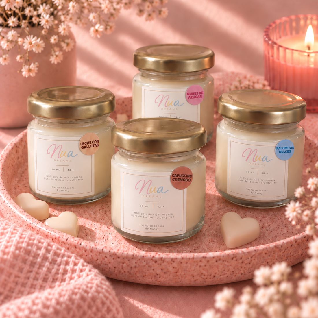 Pack de 4 velas mini de la Colección Recuerdos, con tapa dorada, sobre una bandeja rosa